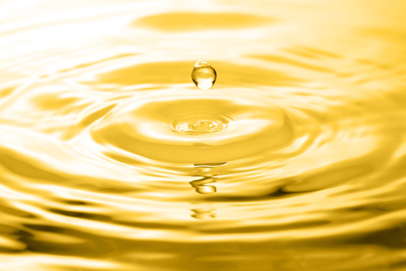A golden drop falling into liquid